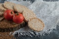 Pile of crispbread, tomatoes and raw buckwheat on wooden piece
