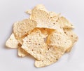 A pile of crispy tortilla chips scattered on a plain white background, perfect for snacking or party menus Royalty Free Stock Photo