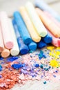 Pile of crushed chalk closeup and rainbow colored pastel crayons Royalty Free Stock Photo