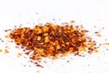 Pile crushed red cayenne pepper, dried chili flakes and seeds isolated on white background Royalty Free Stock Photo
