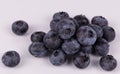 A group of blueberries laying together and several separately on white background