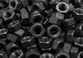 Pile of dark metal hex nuts close up hardware fasteners Royalty Free Stock Photo