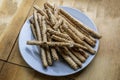 pile of delicious classic crispy bread sticks (grissini) on a white plate