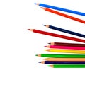 Pile of different colored wood pencil crayons placed on a white paper background