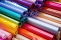 pile of different-coloured plastic gift wrap rolls in a box