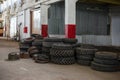 A pile of different tires in a big old industrial garage