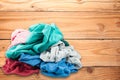 Pile of dirty colorful clothes on wooden floor .