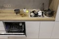 Pile of dirty dishes like plates, cups pot and cutlery in the white kitchen in the light beige granite sink. Open Royalty Free Stock Photo