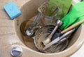 pile of dirty dishes in the sink, green latex gloves and sponge with liquid detergent Royalty Free Stock Photo