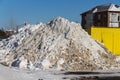 A pile of dirty snow in the yard, cleaning the snow into one pile, pushing the snow into one big pile