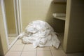 Pile of dirty used towels on the hotel bathroom floor. Housekeeping replace only the used towels on floor with clean ones. Saving Royalty Free Stock Photo