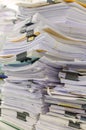 Pile of documents on desk stack up high waiting to be managed Royalty Free Stock Photo