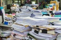 Pile of documents on desk stack up high waiting to be managed