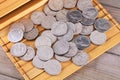 A pile of dollar coins on an unfolded ancient book bamboo slips