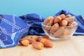 Pile of dried sweet deglet nour date fruites in translucent bowl and dark blue napkin.Organic