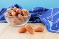 Pile of dried sweet deglet nour date fruites in translucent bowl and dark blue napkin