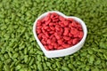 Pile of dry pet food with red color in heart cup , love pet concept. Royalty Free Stock Photo