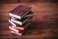 Pile of dusty old books on a wooden background Royalty Free Stock Photo