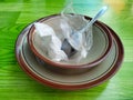 pile of empty plates and bowls with spoons covered in plastic and used food towels Royalty Free Stock Photo