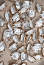 Pile of empty silver-gold candy wrappers. Top view. Royalty Free Stock Photo