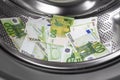 A pile of euro banknotes in the drum of a washing machine