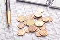 Stack of euro euro coins on old black wooden table. Pen, notebook and accounting documents with numbers Royalty Free Stock Photo