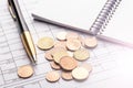 Stack of euro euro coins on old black wooden table. Pen, notebook and accounting documents with numbers Royalty Free Stock Photo