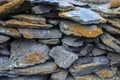 Pile of flat gray stones covered with orange lichen or moss. Natural texture Royalty Free Stock Photo