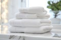 Pile of fluffy white bath towels stacked on a white marble vanity in a luxury bathroom interior. Royalty Free Stock Photo