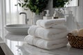 Pile of fluffy white bath towels stacked on a white marble vanity in a luxury bathroom interior. Royalty Free Stock Photo