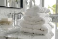 Pile of fluffy white bath towels stacked on a white marble vanity in a luxury bathroom interior. Royalty Free Stock Photo