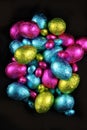 Pile of foil wrapped chocolate easter eggs in pink, blue & lime green Royalty Free Stock Photo