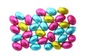 Pile of foil wrapped chocolate easter eggs in pink, blue & lime green with a white background Royalty Free Stock Photo