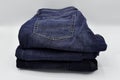 A pile of folded blue skinny jeans on a white background