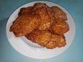 A pile of food called fried tempeh, traditional Indonesian food. Fried fermented soybean meal served on a white plate Royalty Free Stock Photo