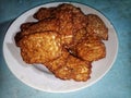 A pile of food called fried tempeh, traditional Indonesian food. Fried fermented soybean meal served on a white plate Royalty Free Stock Photo