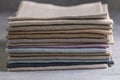 A pile of four folded dull-colored natural linen fabric, close up