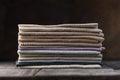 A pile of four folded dull-colored natural linen fabric