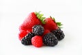 Pile of fresh berries on a white background including strawberries, blackberries and raspberries Royalty Free Stock Photo