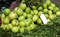 A pile of fresh green guavas stacked on green leaves at the local fruit market