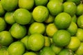 Pile of fresh green limes on market counter. Food background and lime harvest concept Royalty Free Stock Photo