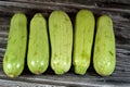 Pile of fresh green zucchini or courgette vegetables isolated on wooden background, selective focus of fresh raw organic squash Royalty Free Stock Photo