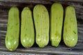 Pile of fresh green zucchini or courgette vegetables isolated on wooden background, selective focus of fresh raw organic squash Royalty Free Stock Photo