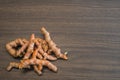 Pile of fresh organic turmeric curcuma root on wooden background with copy space. Food cooking ingredient spice or use for natural