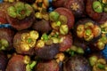 Pile of fresh purple mangosteen or queen of fruits in deep reddish-purple color selling in local market
