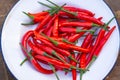 Pile of fresh red chilies pepper on white plate