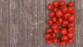 Pile of fresh tomatoes on a wooden table. Top view. Empty space on the left side