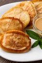 Pile of freshly fried thick pancakes, in Eastern European cuisines called oladky or oladyi with condensed milk on wooden