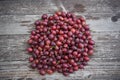 Pile of freshly riped red gooseberries on old wooden table