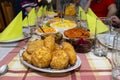 A pile of fried, stuffed Polish croquettes lying on a decorated table, visible mushrooms and beets.